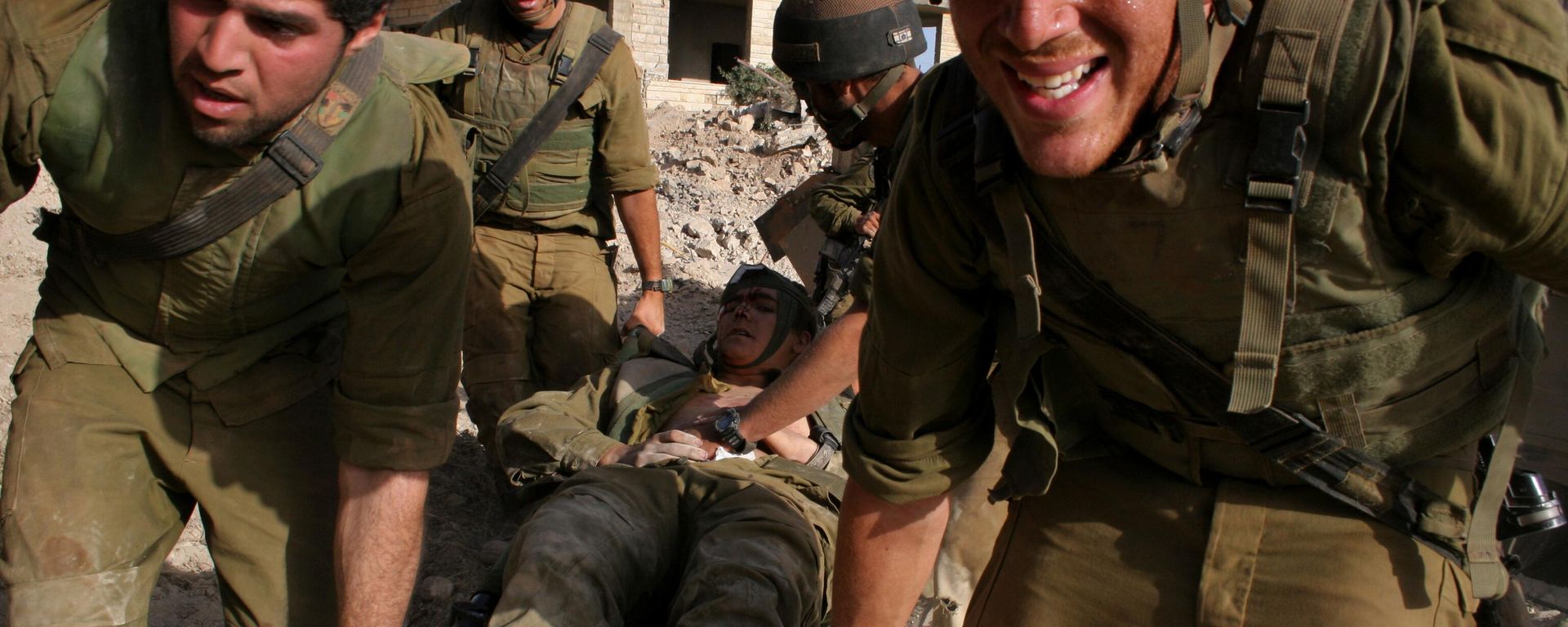 Israeli Army medic Tom Shechter is evacuated by colleagues after the unit came under attack from Hezbollah guerrillas with anti-tank missiles in the village of Inta, outskirts of the southern Lebanon town of Bint Jbail early Saturday Aug. 12, 2006. The unit was clearing routes for armored vehicles and infantry. Israeli Army medic Tom Shechter is evacuated by colleagues after the unit came under attack from Hezbollah guerrillas with anti-tank missiles in the village of Inta, outskirts of the southern Lebanon town of Bint Jbail early Saturday Aug. 12, 2006. The unit was clearing routes for armored vehicles and infantry. - Sputnik International, 1920, 30.09.2024