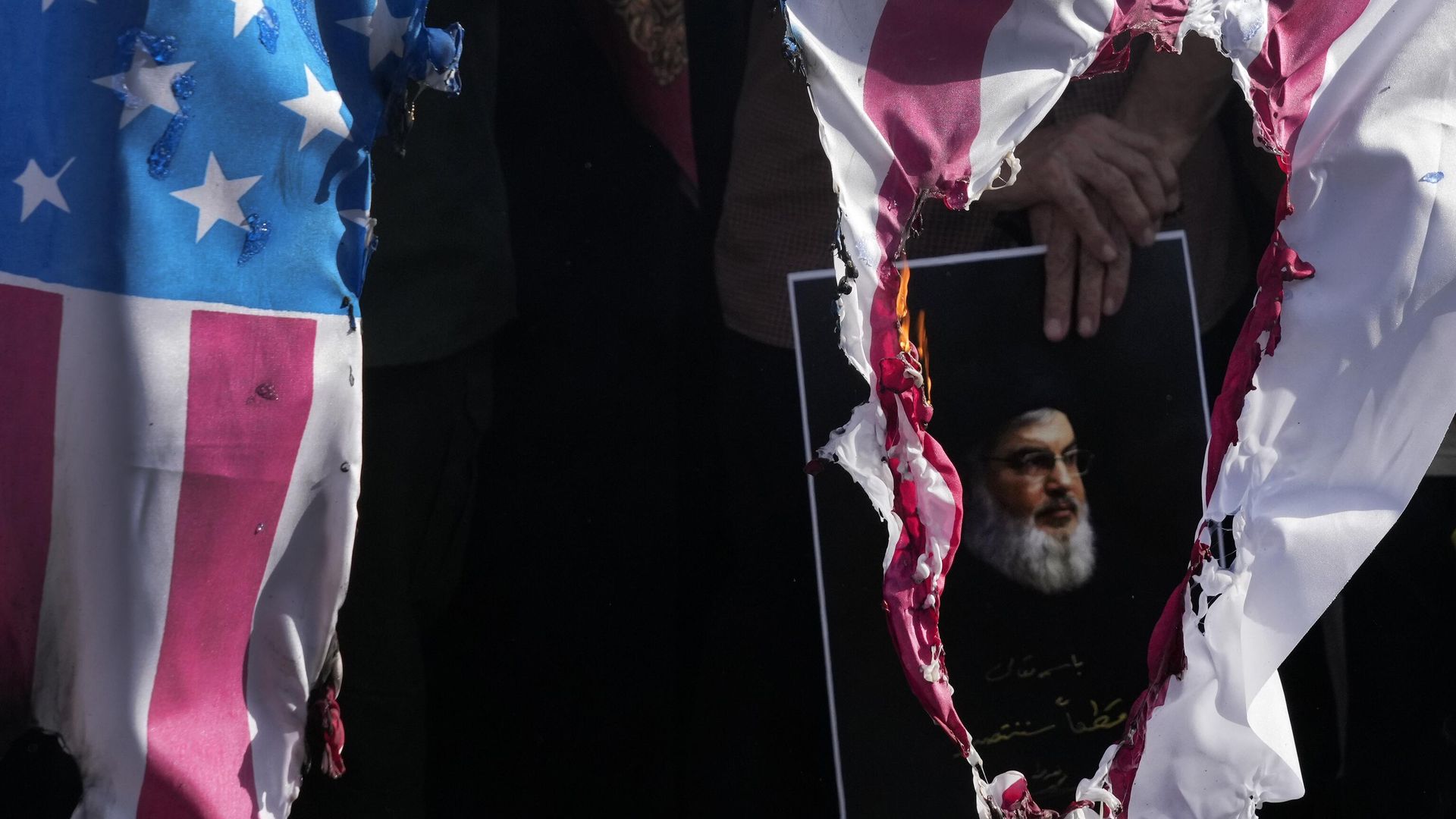 A representation of the US flag is set on fire as a demonstrator holds a poster of slain Hezbollah leader Hassan Nasrallah in a rally commemorating him, in Tehran, Iran, Wednesday, Oct. 2, 2024 A representation of the US flag is set on fire as a demonstrator holds a poster of slain Hezbollah leader Hassan Nasrallah in a rally commemorating him, in Tehran, Iran, Wednesday, Oct. 2, 2024 - Sputnik International, 1920, 05.10.2024