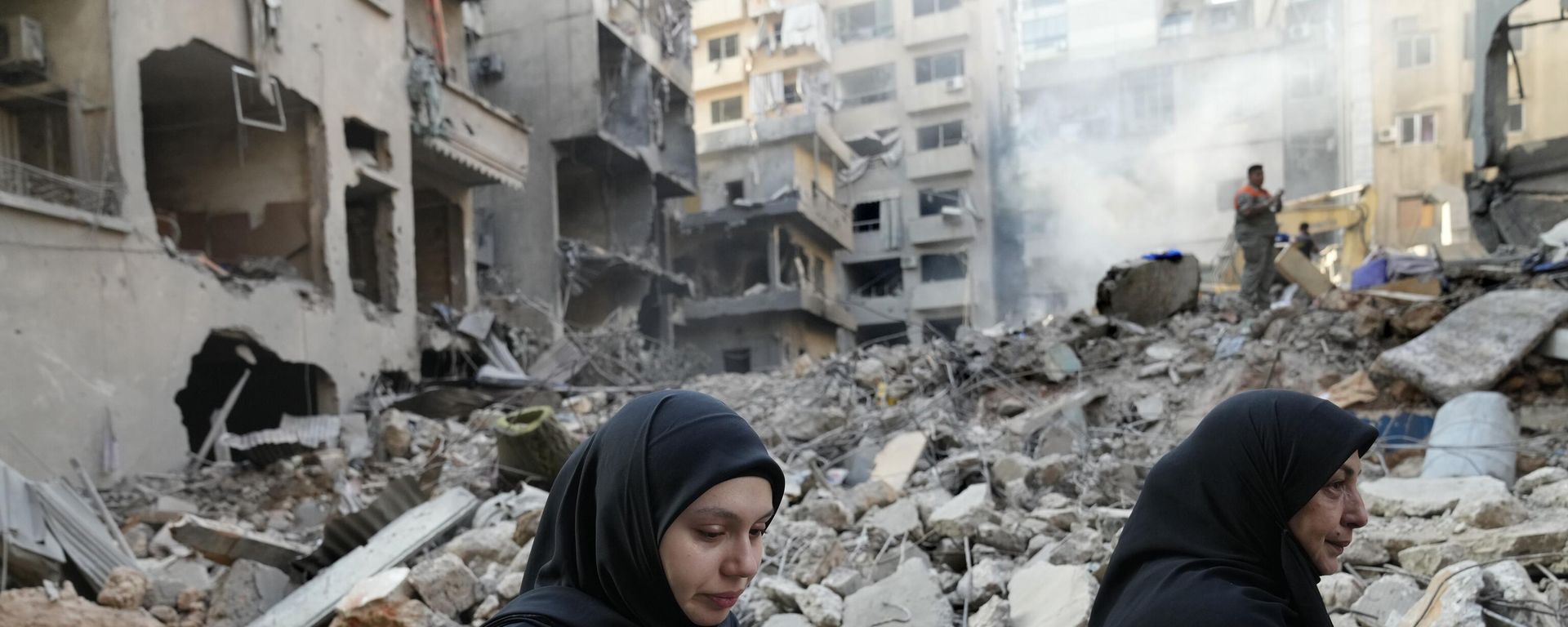 Lebanese women pass the destroyed buildings hit by an Israeli airstrike, in Beirut, Lebanon, Friday, Oct. 11, 2024. Lebanese women pass the destroyed buildings hit by an Israeli airstrike, in Beirut, Lebanon, Friday, Oct. 11, 2024. - Sputnik International, 1920, 21.10.2024