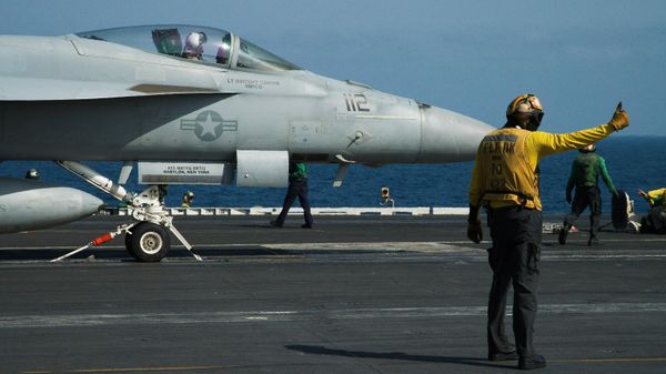 A crew member signals as a pilot prepares to launch an F/A-18 fighter jet on the deck of the USS Abraham Lincoln aircraft carrier in the Arabian Sea. File photo. - Sputnik International