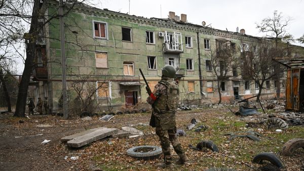 A Russian serviceman stands guard during a demining operation in the town of Selidovo - Sputnik International