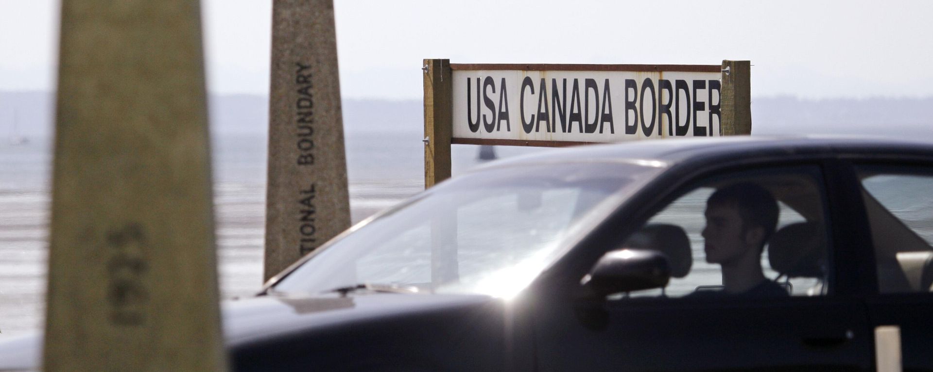 A driver headed toward the U.S. passes border markers Saturday, May 30, 2009, at the border crossing between the U.S. and Canada - Sputnik International, 1920, 25.08.2026