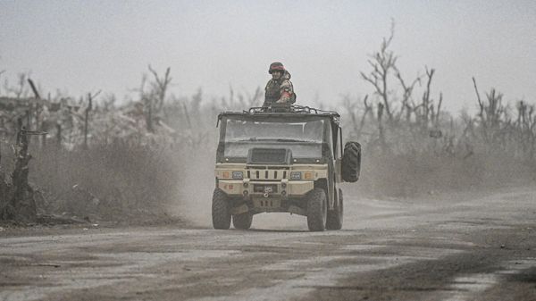 Russian servicemen drive a vehicle in the village of Karlovka, controlled by Russian armed forces, near Krasnoarmeysk  - Sputnik International