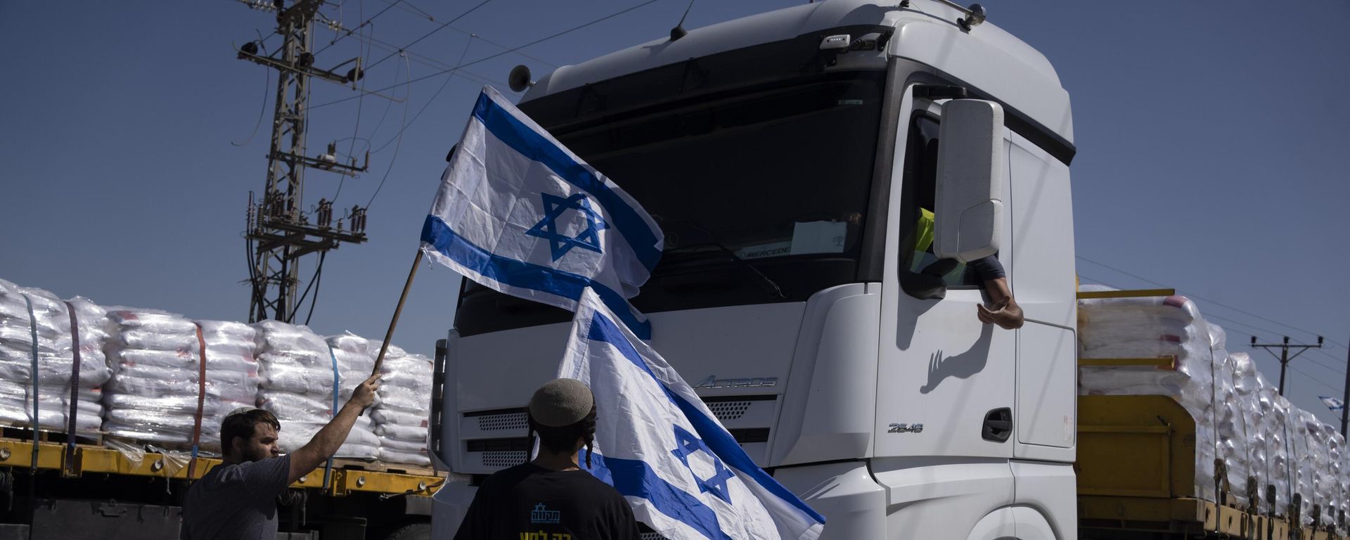 Activists stand in front of trucks carrying humanitarian aid as they try to stop them from entering the Gaza Strip in an area near the Kerem Shalom border crossing, southern Israel, Thursday, May 9, 2024.  - Sputnik International, 1920, 19.05.2025