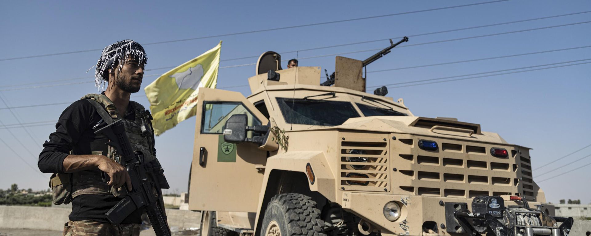 A U.S.-backed Syrian Democratic Forces (SDF) fighter stands next an armored vehicle, at al-Sabha town in the eastern countryside of Deir el-Zour, Syria, Monday, Sept. 4, 2023.  - Sputnik International, 1920, 21.07.2025