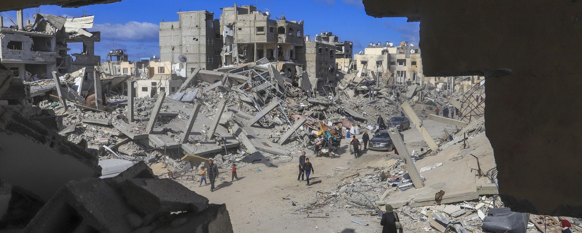 Palestinians walk through the rubble caused by the Israeli air and ground offensive in Rafah, southern Gaza Strip, Monday, Jan. 20, 2025. - Sputnik International, 1920, 13.09.2025