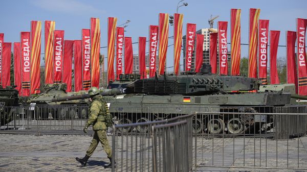 A Russian soldier walks past a Leopard 2A6 tank that belonged to the Ukrainian army is seen on display in Moscow. Tuesday, April 30, 2024. - Sputnik International