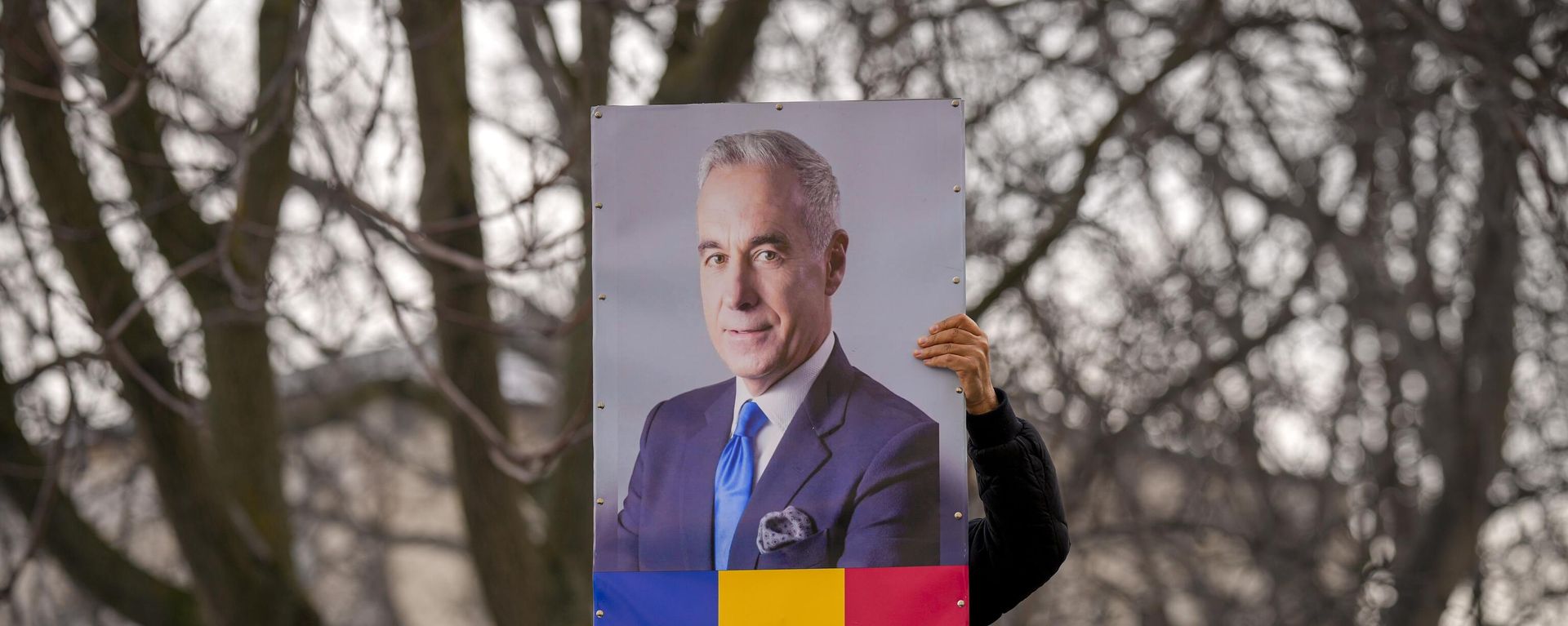 A man holds a portrait of Calin Georgescu, the winner of Romania's first round of presidential election, annulled by the Constitutional Court. File photo - Sputnik International, 1920, 11.03.2025