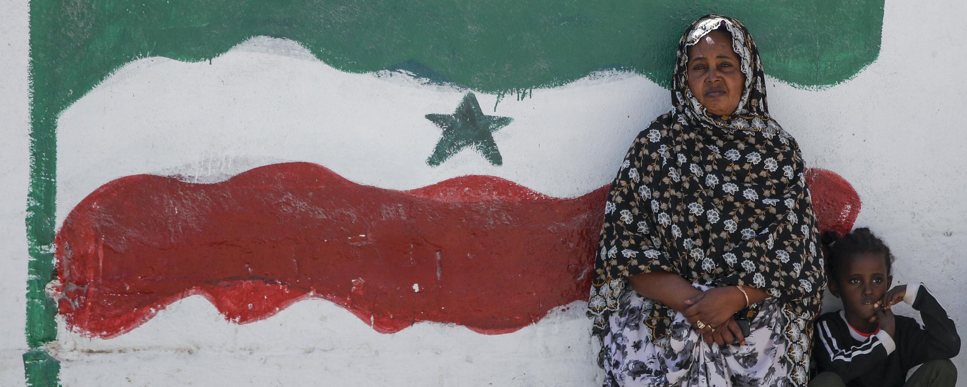 FILE - A woman and child relax next to a mural of Somaliland's flag, in Hargeisa, Somaliland, a semi-autonomous breakaway region of Somalia - Sputnik International, 1920, 14.03.2025