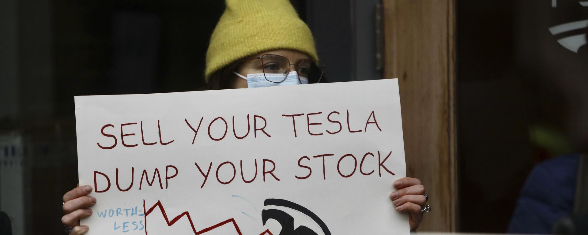  A person protesting Elon Musk's actions in the Trump administration holds a sign outside a Tesla showroom in Seattle on Thursday, Feb. 13, 2025.  - Sputnik International, 1920, 22.03.2025