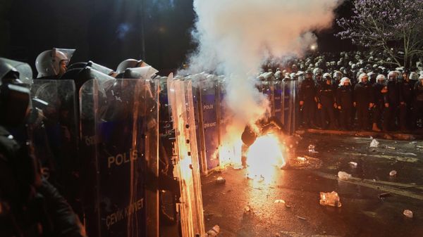 A protester holds a flare next to riot police officers during a protest against the arrest of Istanbul Mayor Ekrem Imamoglu, in Istanbul, Turkey, Saturday, March 22, 2025 - Sputnik International