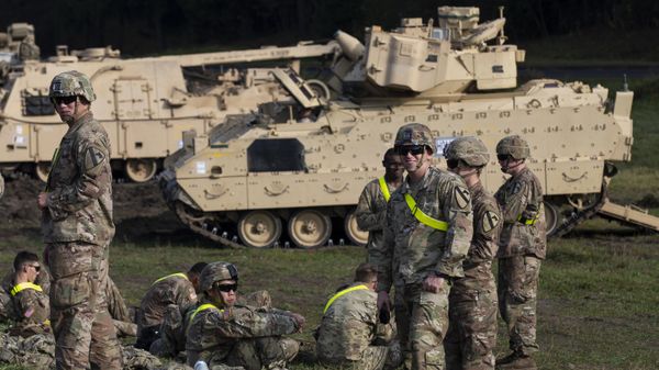 Members of the US Army's 1st Armoured Battalion of the 9th Regiment, 1st Division from Fort Hood in Texas rest next to Bradley Infantry Fighting Vehicles after arriving at the Pabrade railway station some 50 km (31 miles) north of the capital Vilnius, Lithuania, Monday, Oct. 21, 2019. - Sputnik International