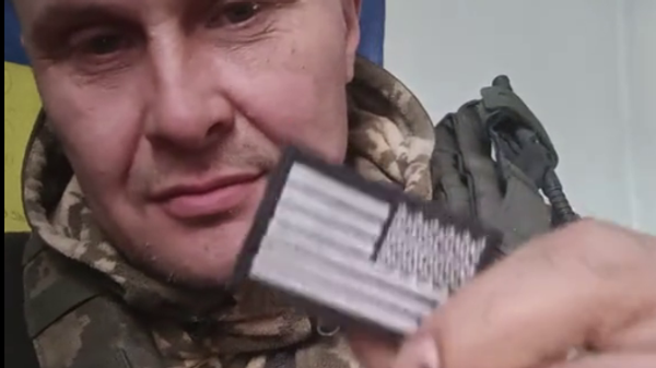 Ukrainian soldier tears off the US emblem from his uniform  - Sputnik International