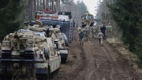 US Army soldiers walk during recovery efforts for four missing US soldiers near the spot where their Hercules armored vehicle was found submerged at a training range in Pabrade, north of the capital Vilnius, Lithuania on Friday, March 28, 2025. - Sputnik International