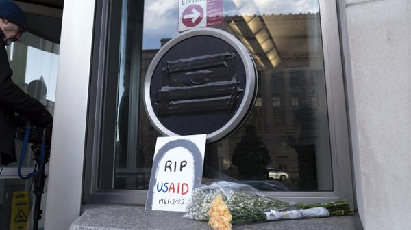Flowers and a sign are placed outside the headquarters of the U.S. Agency for International Development, or USAID, Friday, Feb. 7, 2025, in Washington.  - Sputnik International