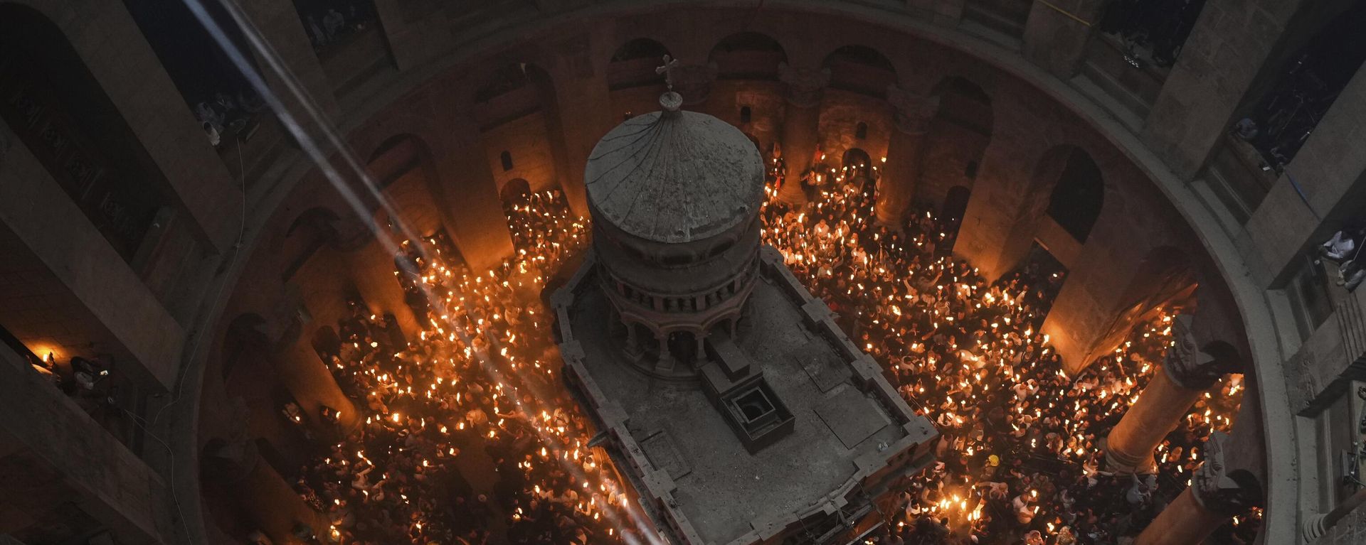 Christian pilgrims hold candles during the Holy Fire ceremony, a day before Easter, at the Church of the Holy Sepulcher, where many Christians believe Jesus was crucified, buried and resurrected, in Jerusalem's Old City. File photo. - Sputnik International, 1920, 18.04.2025