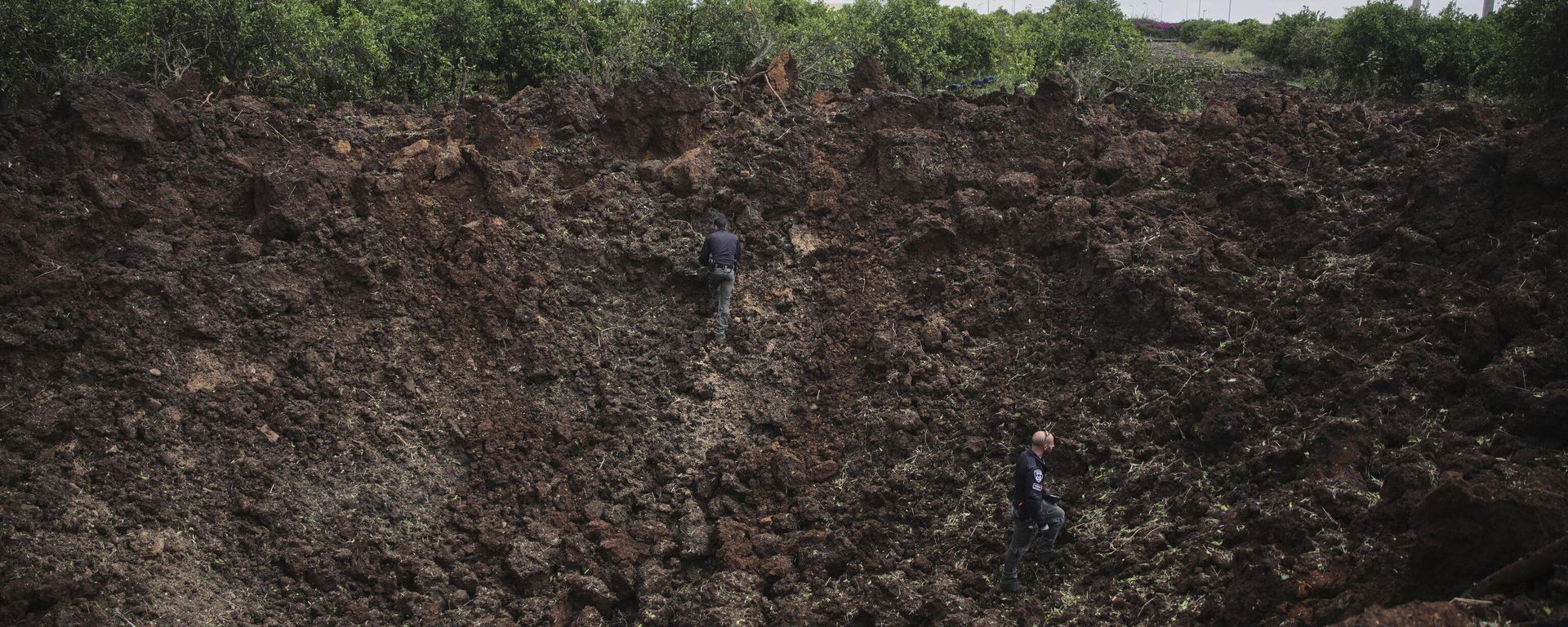 Israeli security forces inspect a crater at the site where the Israeli military said a projectile fired by Yemen's Houthi rebels landed in the area of Ben Gurion International Airport near Tel Aviv, Israel, on Sunday, May 4, 2025.  - Sputnik International, 1920, 04.05.2025