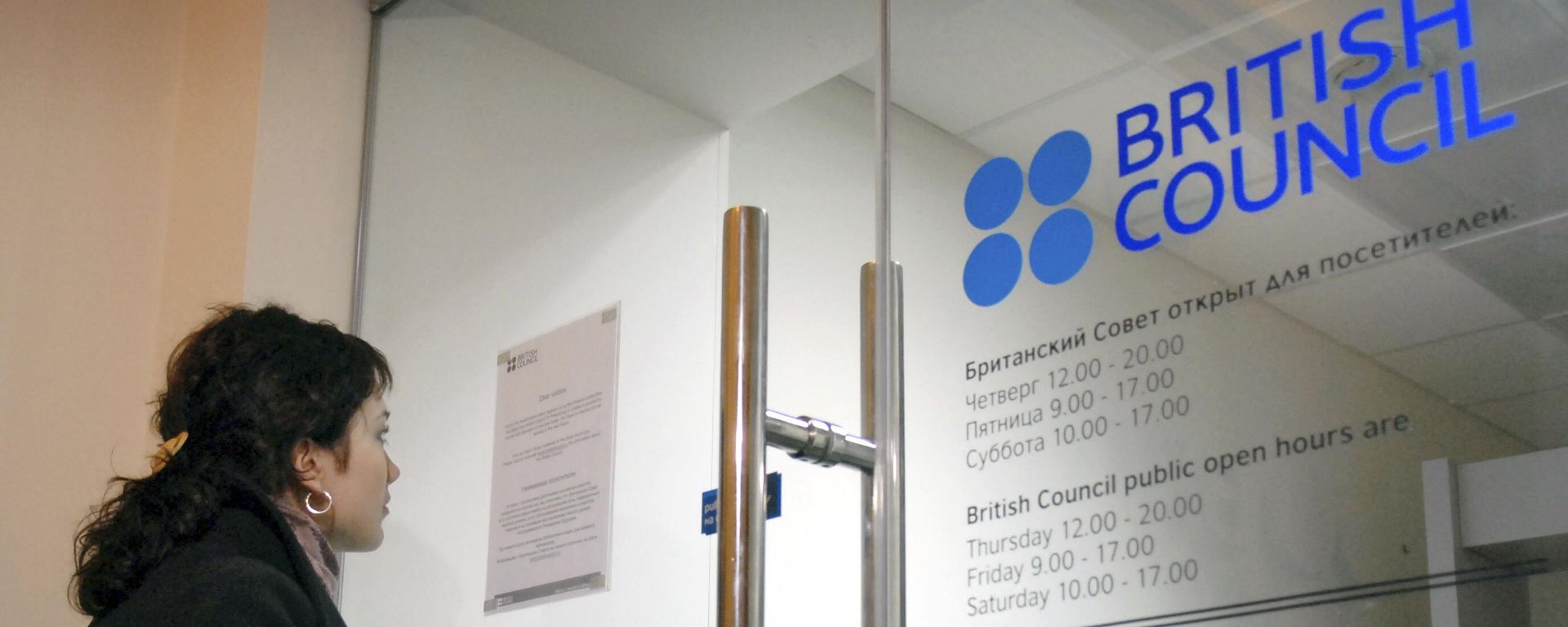 A woman looks at the temporary closure notice at the entrance to the British Council office in St. Petersburg, Russia. File photo. - Sputnik International, 1920, 05.06.2025