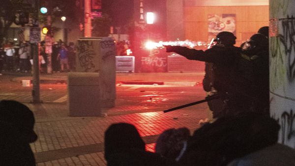 Police take cover from projectiles during protests over the Trump administration's immigration raids in Los Angeles, Monday, June 9, 2025.  - Sputnik International