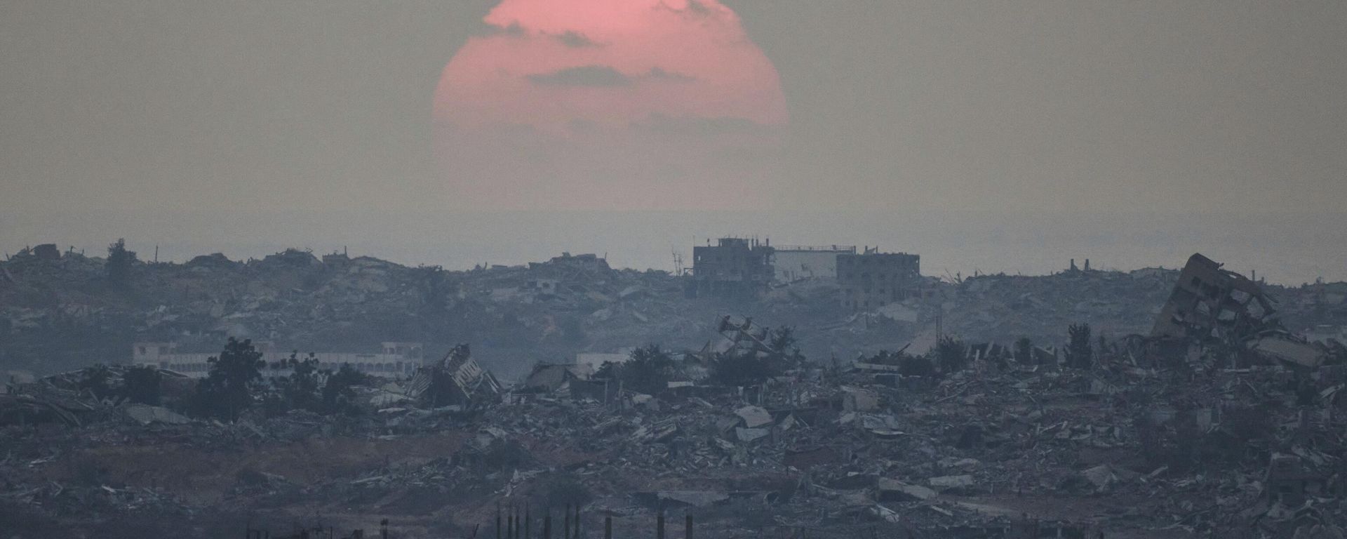 The sun sets behind buildings destroyed during Israeli ground and air operations in the northern Gaza Strip, as seen from southern Israel, Aug. 8, 2025 - Sputnik International, 1920, 16.09.2025