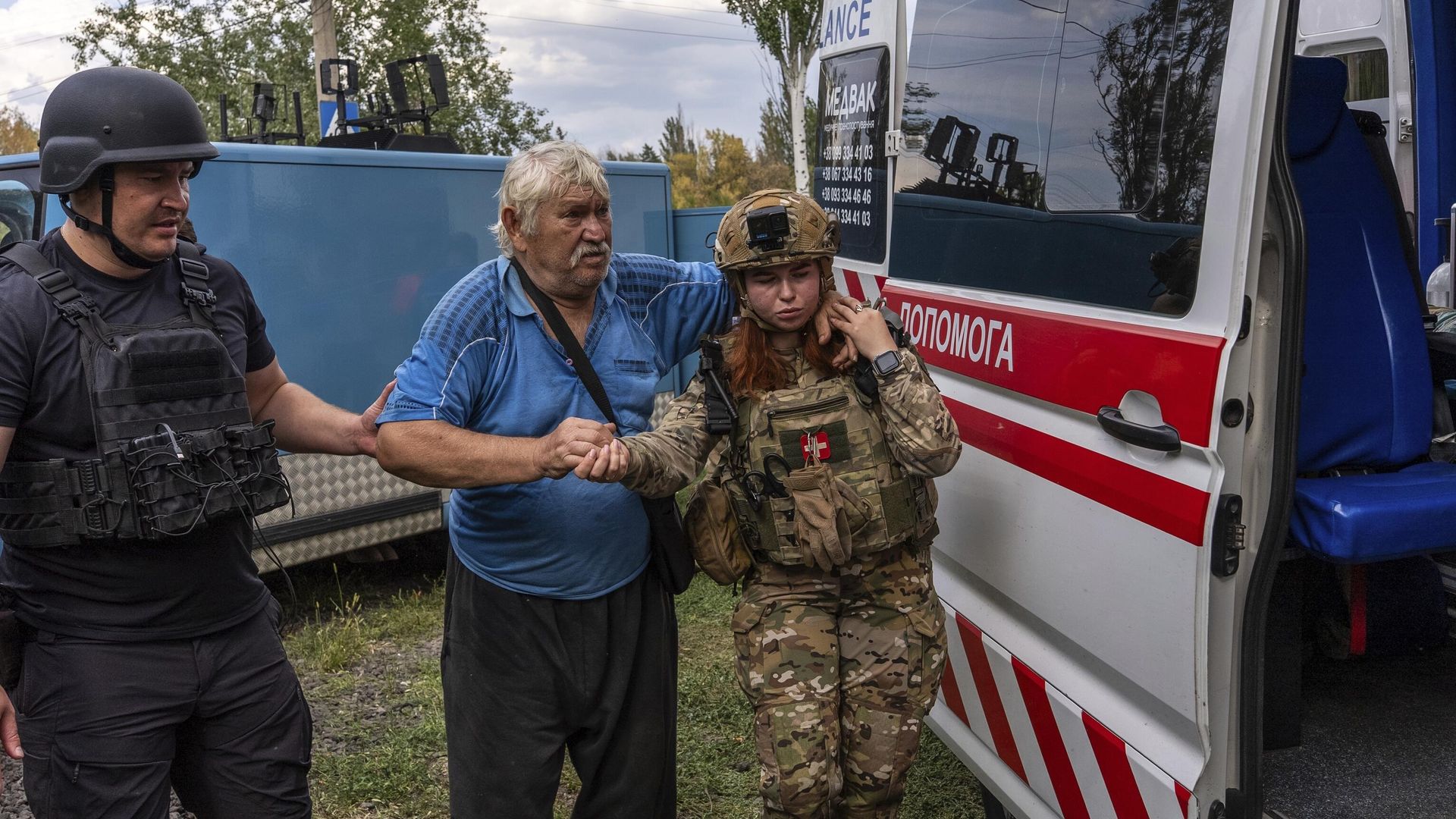 Police officers help Mykola Puzyk, 70, who lost his wife Tetiana Puzyk, 68, to move from an armored car to a ambulance from the village of Yarova. September 9, 2025. - Sputnik International, 1920, 09.09.2025