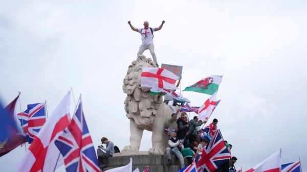A demonstrator stands on the head of the South Bank lion that sits on the side of the Westminster Bridge, during a Tommy Robinson-led Unite the Kingdom march and rally in London - Sputnik International