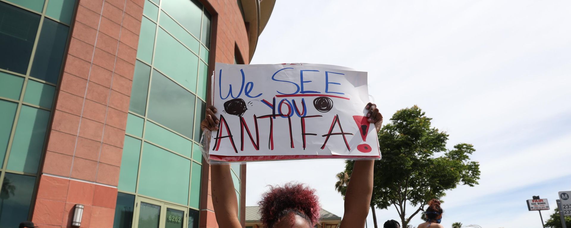 A woman holds a sign addressing ANTIFA at a protest in Los Angeles A woman holds a sign addressing ANTIFA at a protest in Los Angeles - Sputnik International, 1920, 23.09.2025