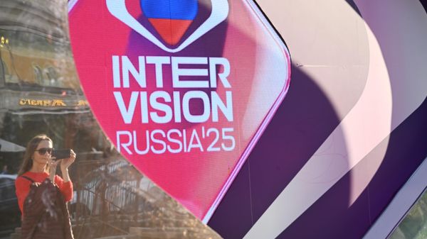 A girl stands next to a banner for the Intervision International Music Competition on Manezhnaya Square in Moscow. - Sputnik International