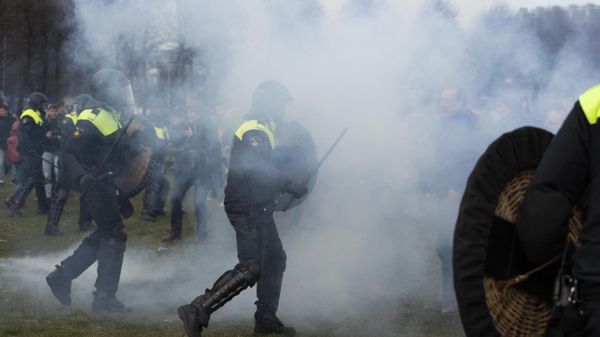 Dutch riot police advance through a cloud from fireworks  - Sputnik International