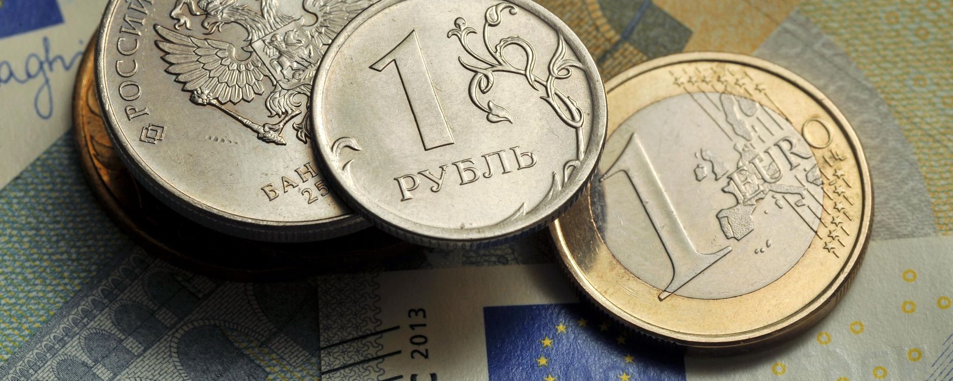 Coins of 1 ruble and 1 euro against the background of a 5 euro banknote. Coins of 1 ruble and 1 euro against the background of a 5 euro banknote. - Sputnik International, 1920, 25.12.2025