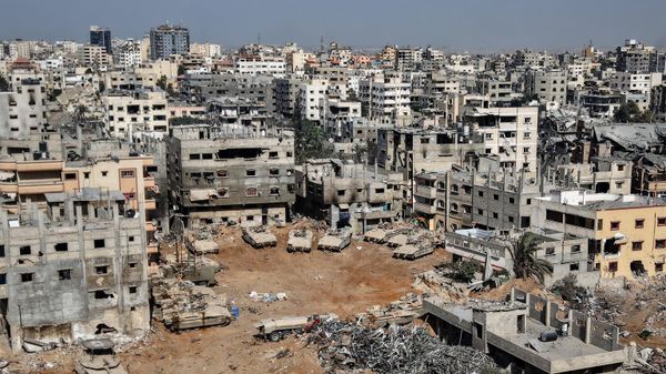 This aerial picture taken during a media tour organised by the Israeli army, shows Israeli army tanks and armoured personnel carriers stationed amid war-damaged buildings in the vicinity of the Jordanian Field Hospital in Gaza City, Friday, Oct. 3, 2025.  - Sputnik International