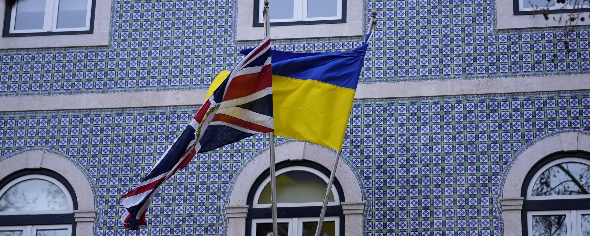 The United Kingdom and Ukraine flags fly on the balcony of the UK embassy in Lisbon, March 4, 2022.  - Sputnik International, 1920, 05.12.2025