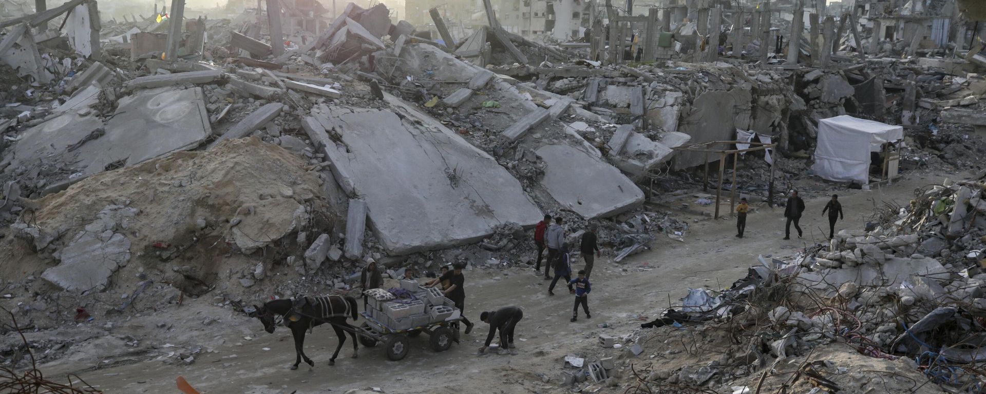 People walk amid the destruction caused by the Israeli air and ground offensive in Jabaliya, Gaza Strip, on Tuesday, Feb. 18, 2025 - Sputnik International, 1920, 21.10.2025