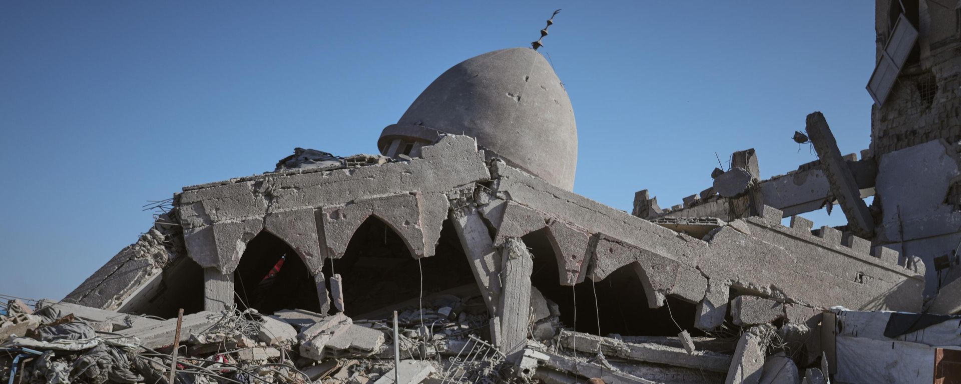A Palestinian woman carrying her child walks past a destroyed mosque in Gaza City Sunday, Oct. 26, 2025. A Palestinian woman carrying her child walks past a destroyed mosque in Gaza City Sunday, Oct. 26, 2025. - Sputnik International, 1920, 18.11.2025