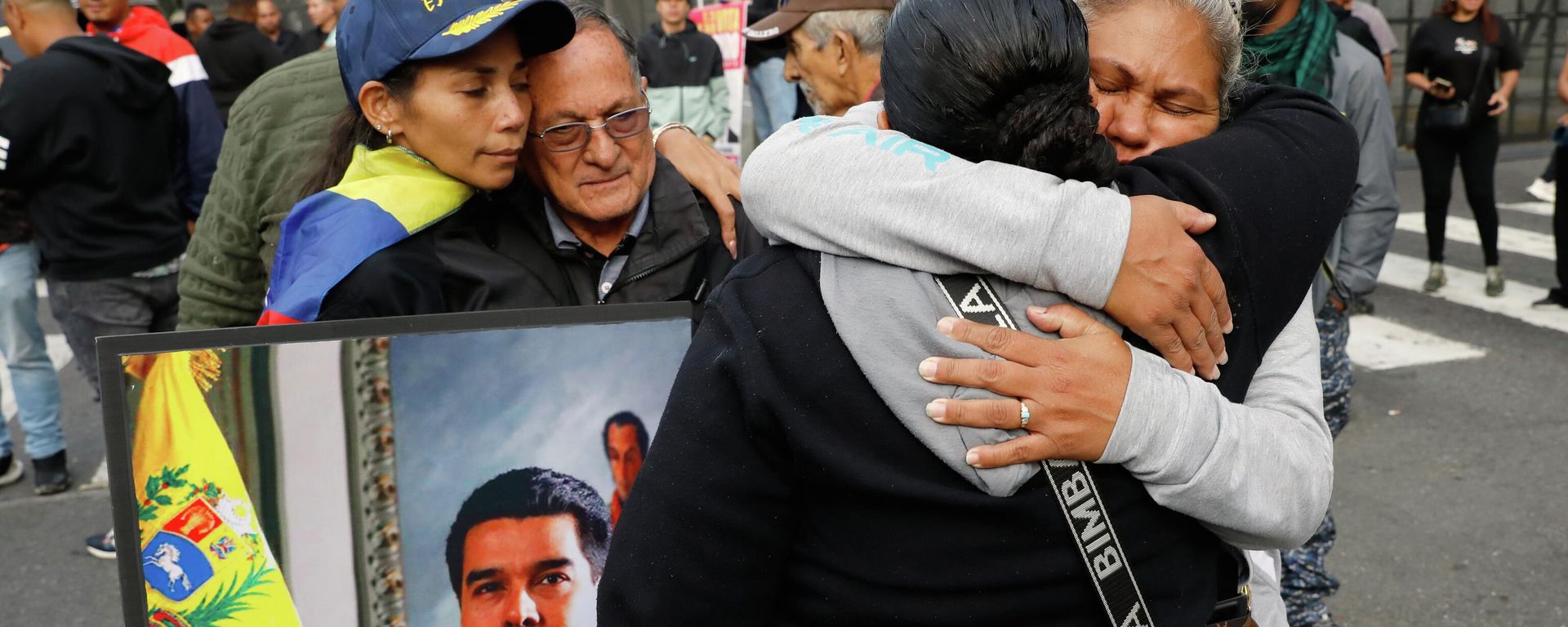 Supporters of Venezuelan President Nicolás Maduro embrace in downtown Caracas, Venezuela, Saturday, Jan. 3, 2026 - Sputnik International, 1920, 03.01.2026