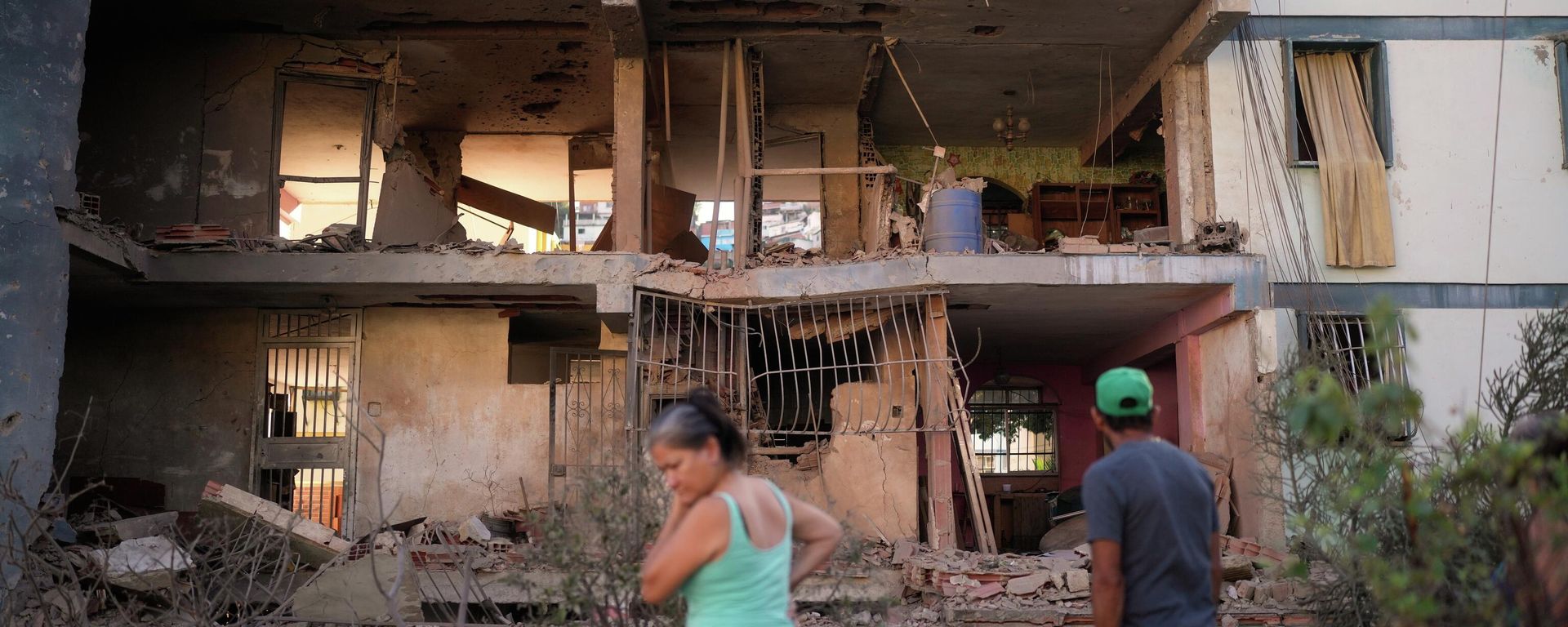 Residents look at a damaged apartment complex that neighbors say was hit during US strikes to capture Venezuelan President Nicolás Maduro, in Catia La Mar, Venezuela, Sunday, Jan. 4, 2026.  - Sputnik International, 1920, 07.01.2026