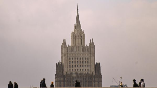 Pedestrians on the Bolshoy Moskvoretsky Bridge in Moscow. In the background is the Russian Ministry of Foreign Affairs building on Smolenskaya-Sennaya Square. - Sputnik International