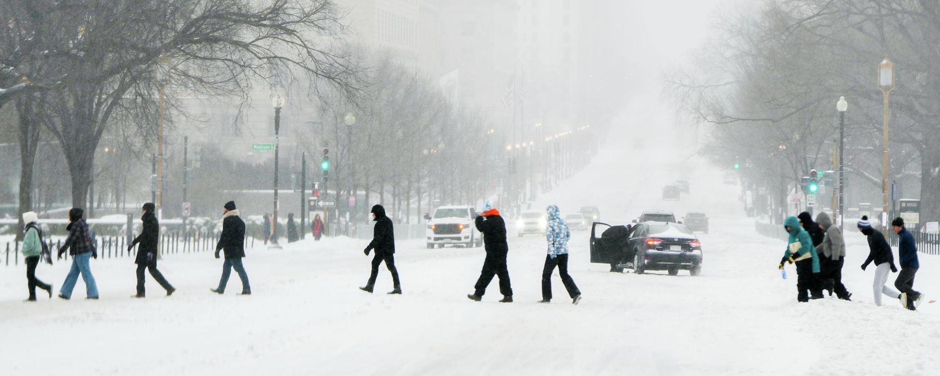 People cross a street during a snowstorm, Sunday, Jan. 25, 2026, in Washington - Sputnik International, 1920, 26.01.2026