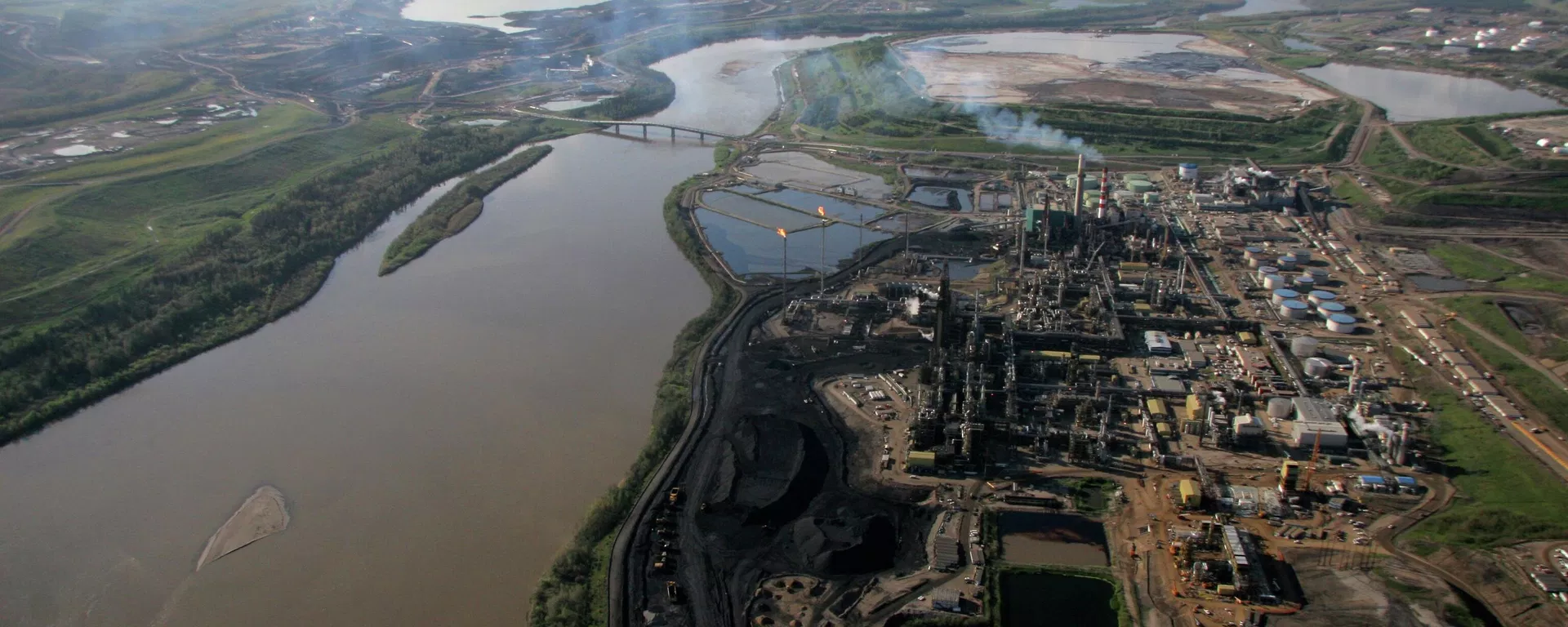 This June 25, 2008 photo shows an aerial view of Alberta's Athabasca river running through the oil sands developments in Canada - Sputnik International, 1920, 15.02.2026