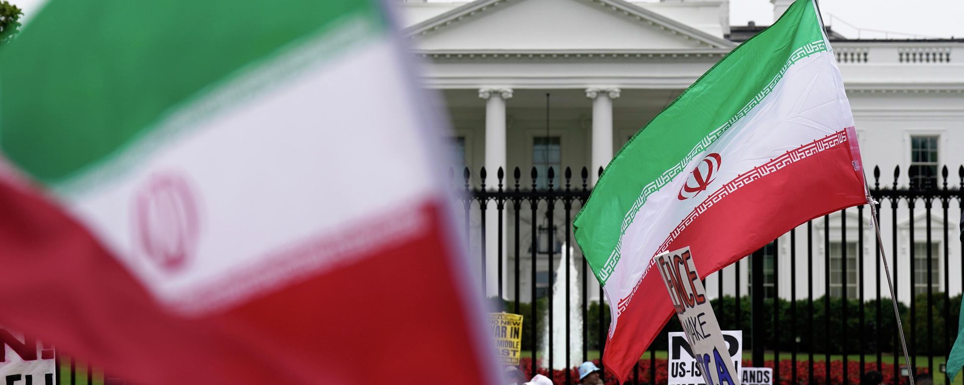 Demonstrators carry signs and wave the Iranian flag as they rally outside the White House, Sunday, June 22, 2025, in Washington, to protest the U.S. military strike on three sites in Iran early Sunday.  - Sputnik International, 1920, 21.06.2026