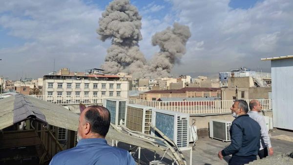 People watch as smoke rises on the skyline after an explosion in Tehran, Iran, Saturday, Feb. 28, 2026.(AP Photo) - Sputnik International