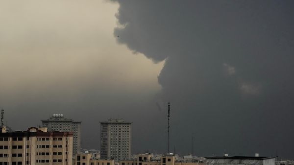 Plumes of smoke from a U.S.-Israeli strike on an oil facility late Saturday linger in the cloudy sky over Tehran, Iran, Sunday, March 8, 2026. (AP Photo/Vahid Salemi) - Sputnik International