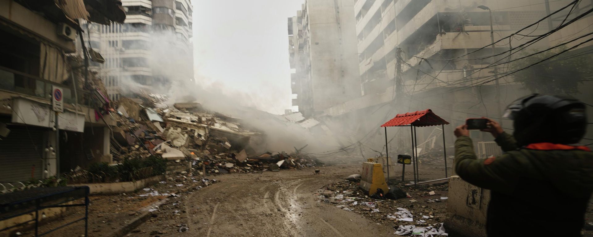 A man photographs the rubble of buildings destroyed in an Israeli airstrike in Dahiyeh, Beirut's southern suburbs, Lebanon, Sunday, March 15, 2026. (AP Photo/Hassan Ammar) - Sputnik International, 1920, 08.07.2026
