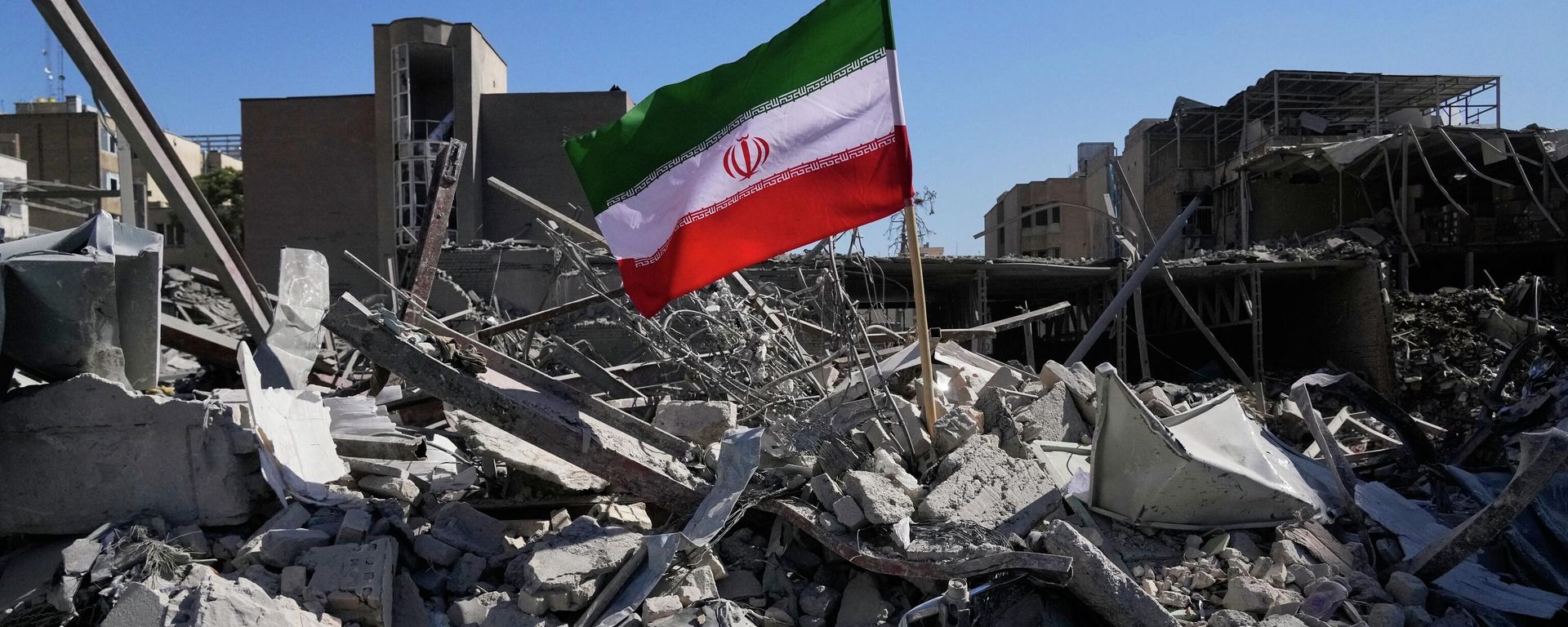 An Iranian flag is placed among the ruins of a police station struck Monday during the U.S.–Israeli military campaign in Tehran, Iran, Tuesday, March 3, 2026. (AP Photo/Vahid Salemi) - Sputnik International, 1920, 06.06.2026