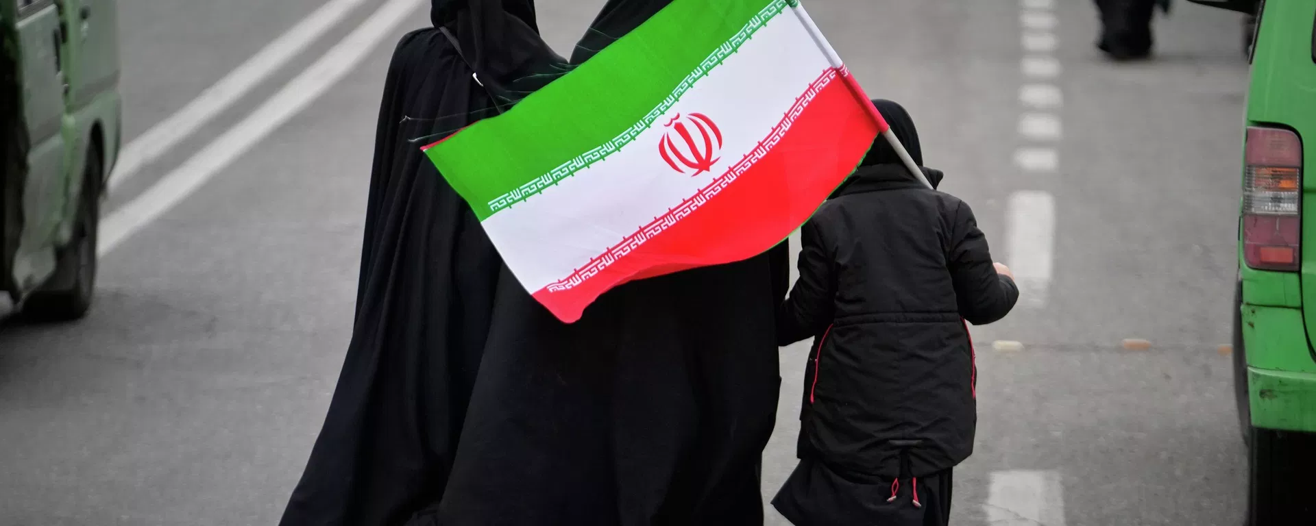 Two women and a child holding an Iranian flag walk toward the Imam Khomeini Grand Mosque to attend Friday prayers in Tehran, Iran, Friday, March 20, 2026. - Sputnik International, 1920, 30.08.2026