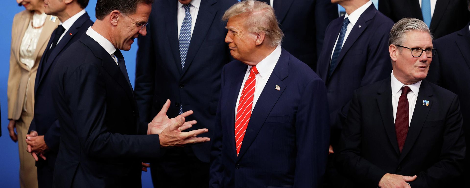 President Donald Trump, center, speaks with NATO Secretary General Mark Rutte, left, during a group photo of NATO heads of state and government at the NATO summit in The Hague, Netherlands, Wednesday, June 25, 2025. - Sputnik International, 1920, 13.04.2026