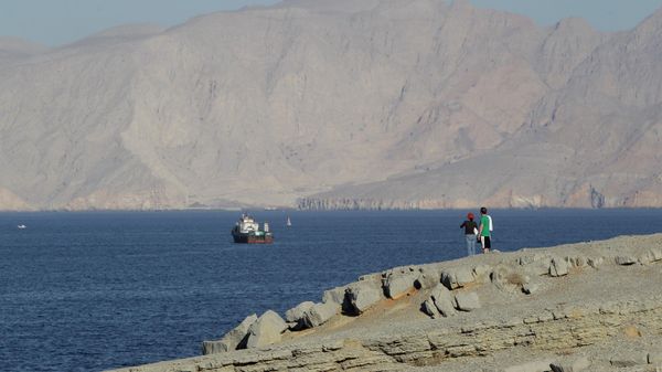 A tourist couple watches the mountains in south of the Strait of Hormuz as the trading dhows and ships are docked on the Persian Gulf waters near the town of Khasab, in Oman - Sputnik International
