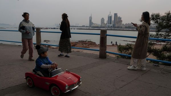 A child drives a toy car along the coast line of Qingdao in eastern China's Shandong province on Monday, April 22, 2024.  - Sputnik International