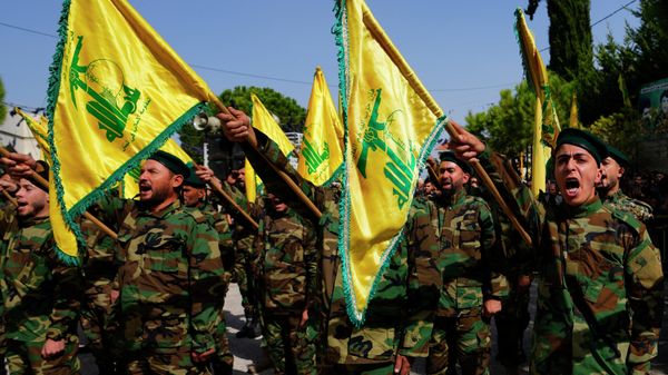 Hezbollah fighters rise their group's flag and shout slogans, as they attend the funeral procession of Hezbollah fighter, Bilal Nemr Rmeiti, who was killed by Israeli shelling, during his funeral procession in Majadel village, south Lebanon, Sunday, Oct. 22, 2023 - Sputnik International