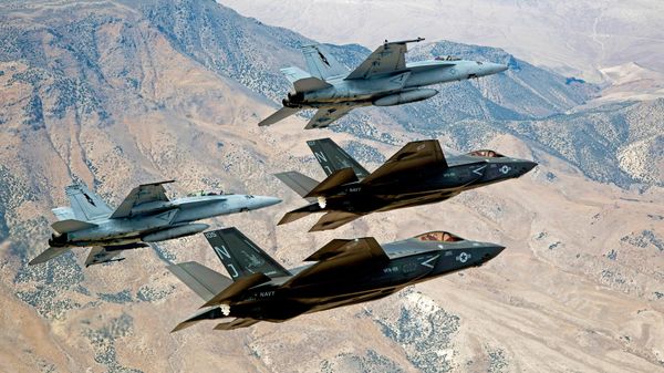 In this Sept. 3, 2015, file photo provided by the US Navy, F-35C Lightning IIs, attached to the Grim Reapers of Strike Fighter Squadron (VFA) 101, and F/A-18E/F Super Hornets attached to the Naval Aviation Warfighter Development Center (NAWDC) fly over Naval Air Station Fallon's (NASF) Range Training Complex near Fallon - Sputnik International